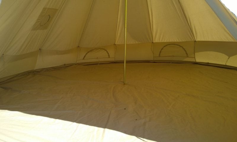 Interior of a bell tent showing the bare canvas, groundsheet and central pole — the base package