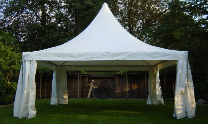 A single white 6m pagoda with its sides partially open in a suburban English garden in late afternoon light