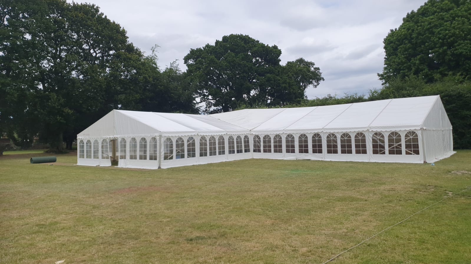 Long white traditional marquee viewed from the front-left with a full run of arched window walls